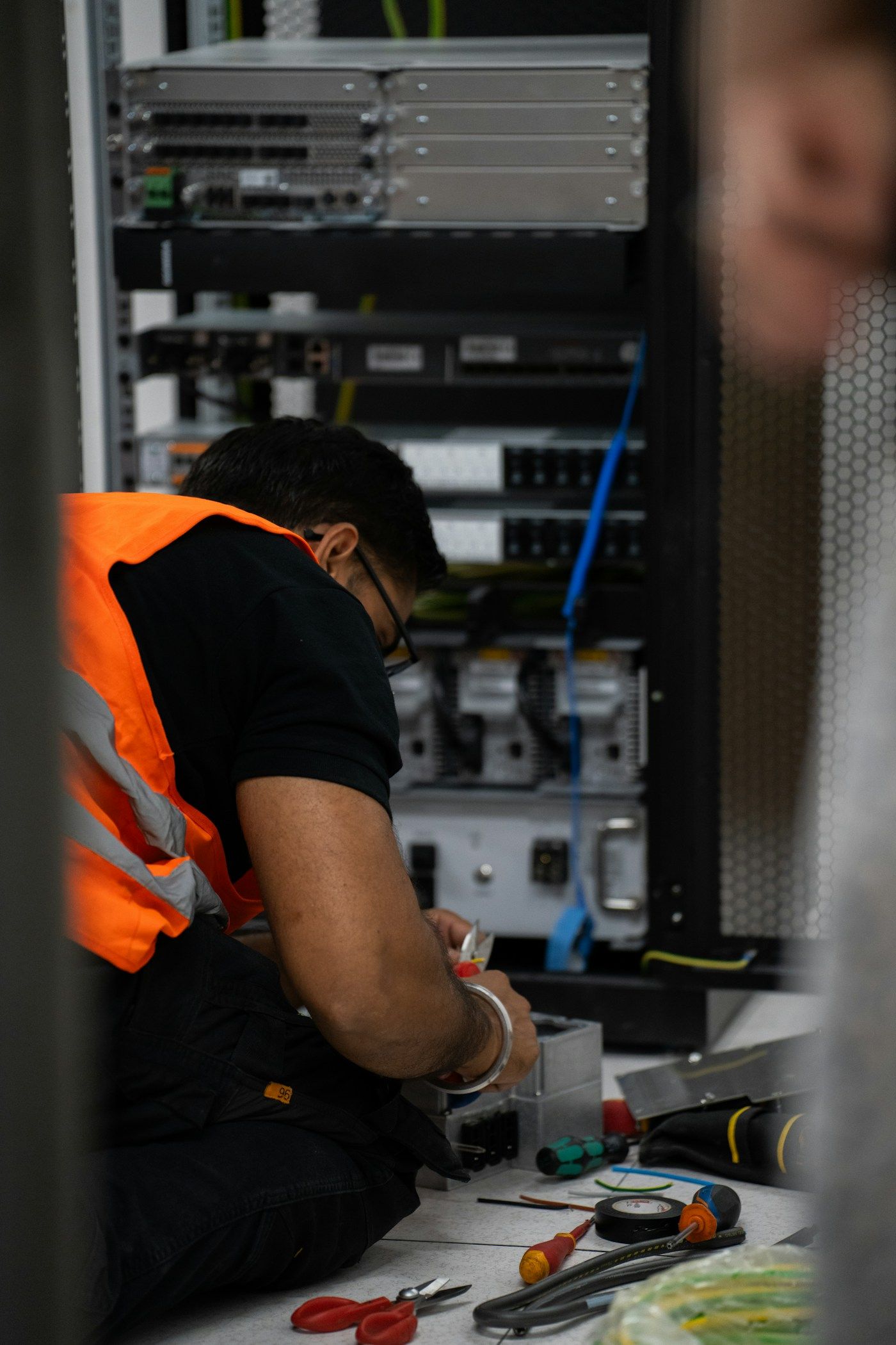 Technician working on network equipment in a server rack