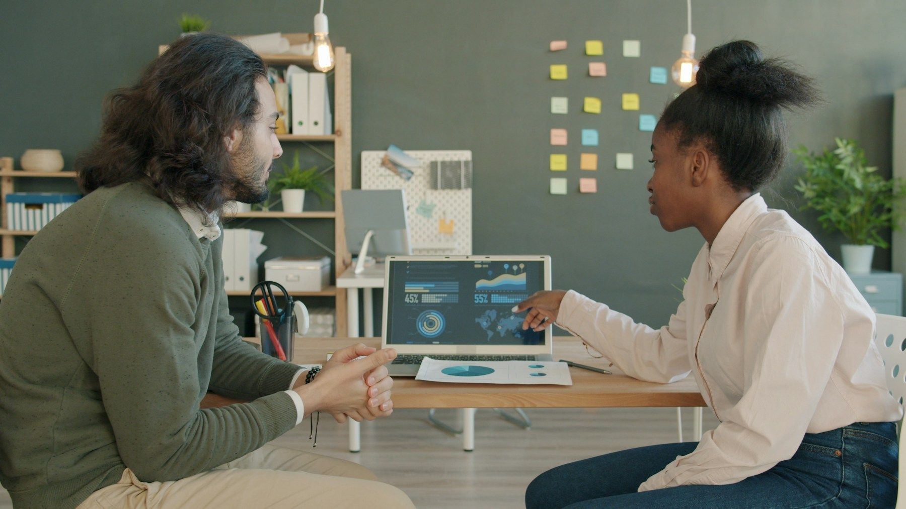 Two colleagues reviewing business data on a laptop
