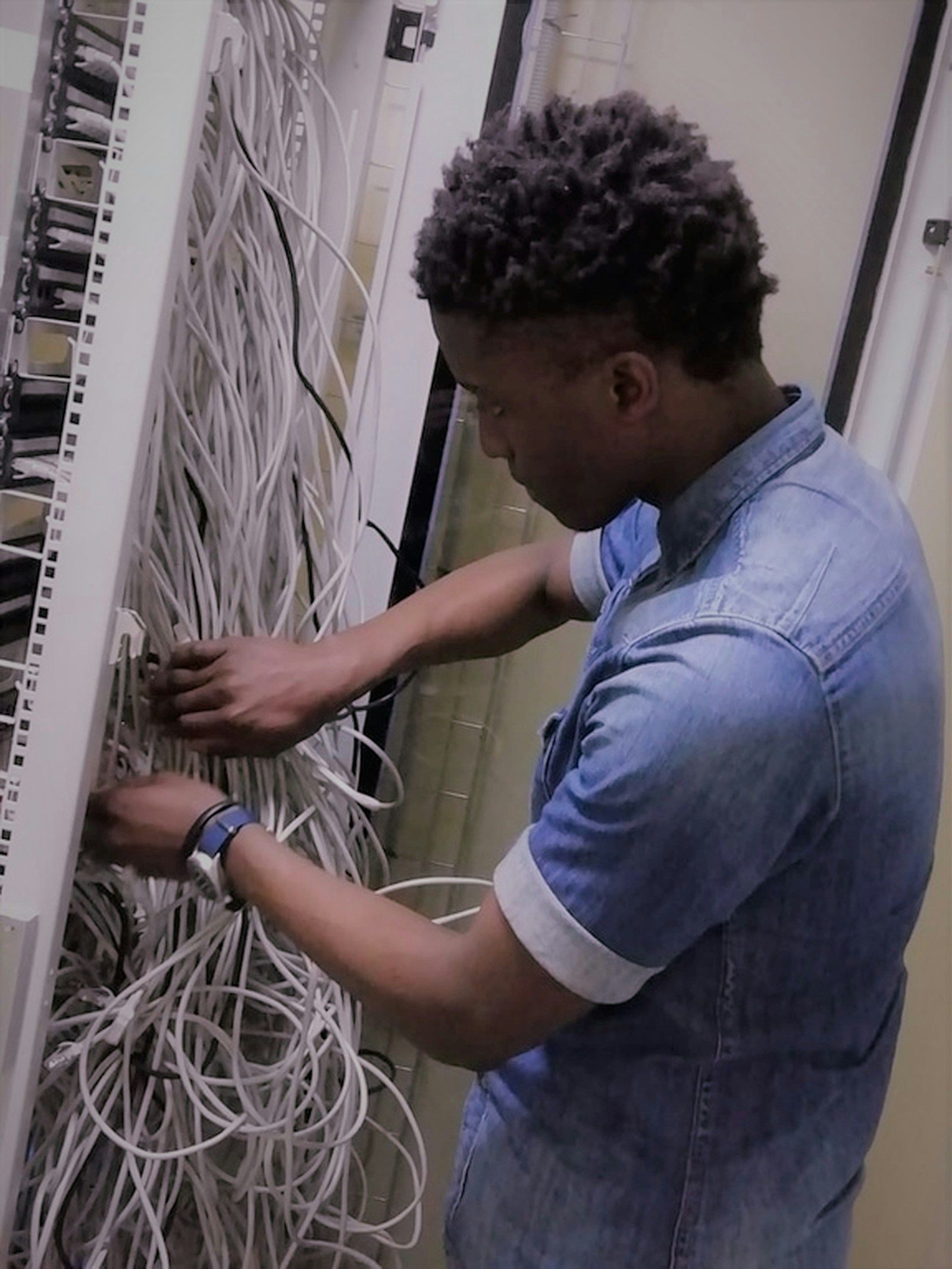Technician organising network cabling in an equipment rack